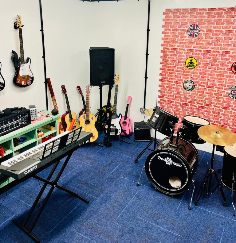Keyboard, guitars, amplifier and drum kit in the music room
