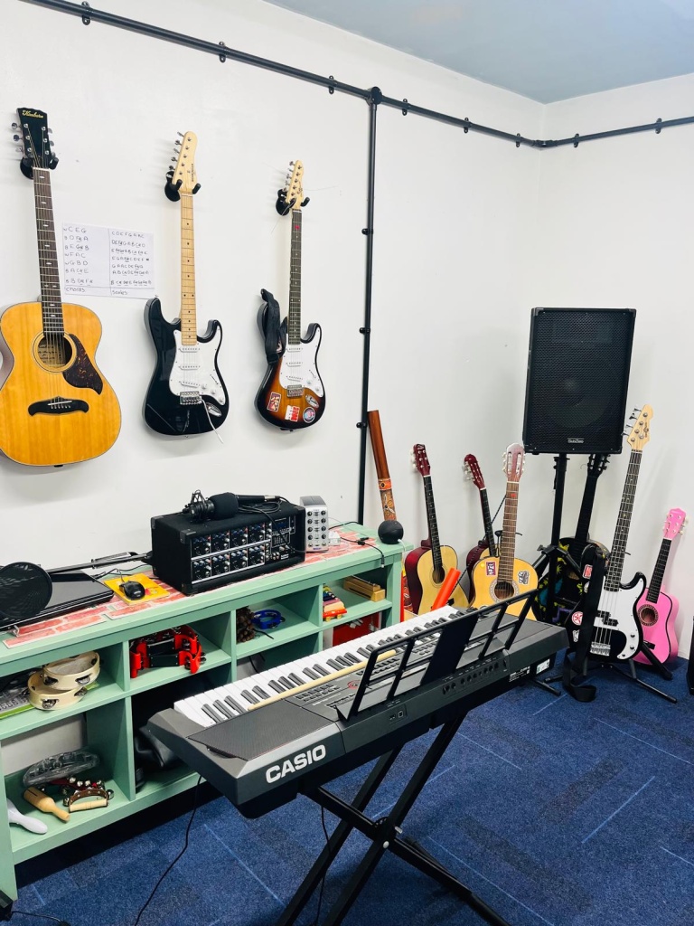 Guitars on the wall above the mixing desk, keyboard and percussion store
